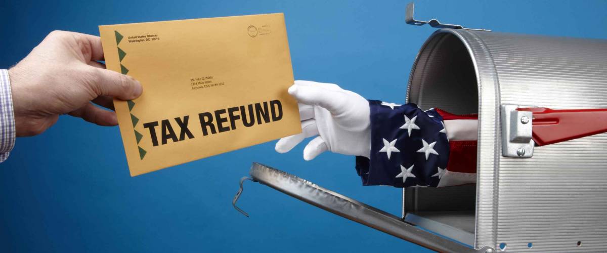 Uncle Sam's arm comes through mailbox to give/take tax refund, includes space for copy