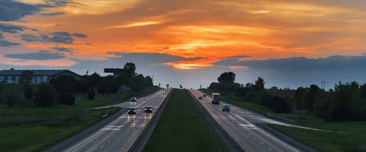 highway with sunset on the horizon. Iowa, I-80 road, USA. Aerial view