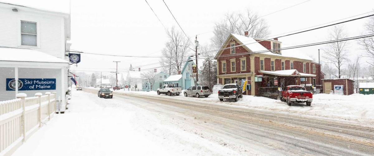 Kingfield, Maine / USA - December 31 2019: Winter storm covers the town of Kingfield, Maine. Photograph is looking north up highway 27 towards Sugarloaf ski resort.