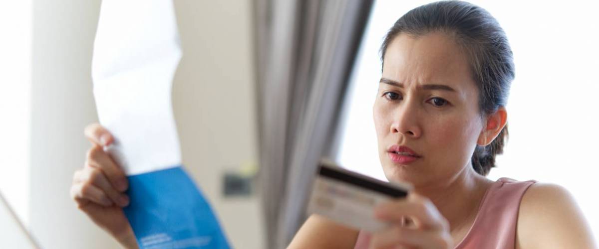 Woman holding bill and credit card