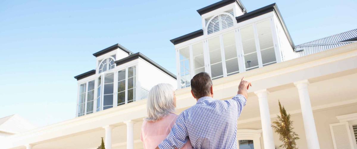 Senior Couple Standing Outside Dream Home