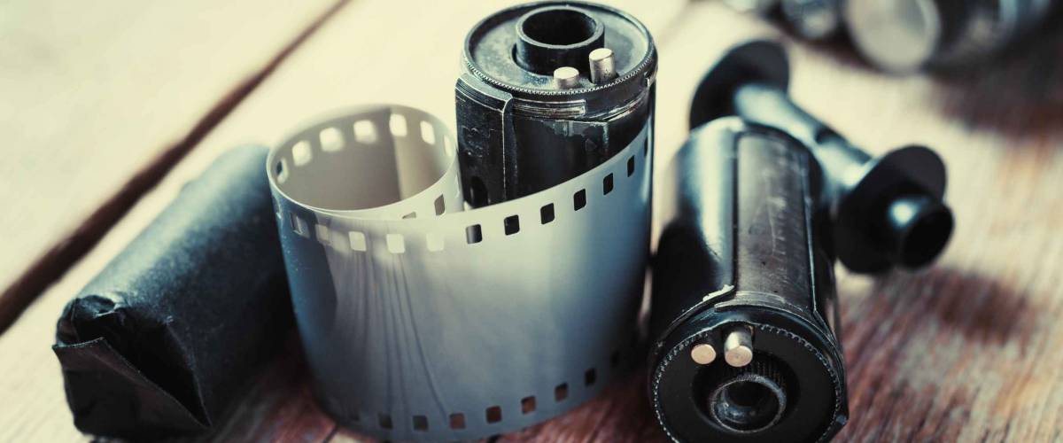 Old photo film rolls, cassette and retro camera on background. Vintage stylized.