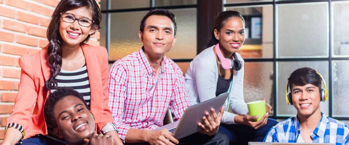 A group of diverse college students learning on campus