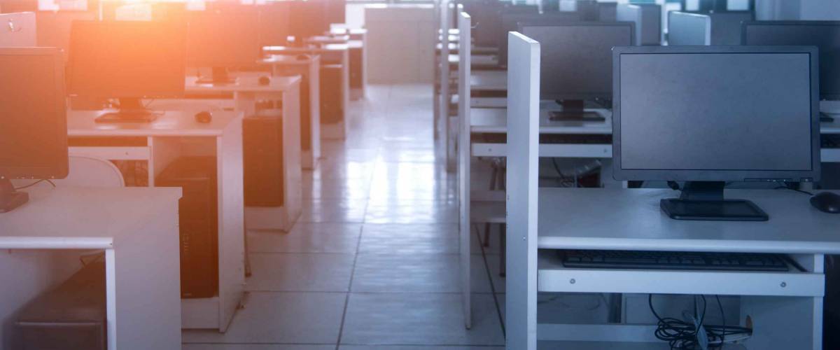 Rows of computer neatly placed in a computer lab.