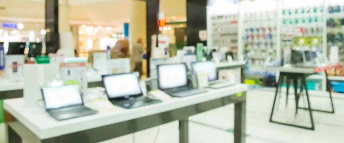 Blurred interior shop with computers and office equipment for background