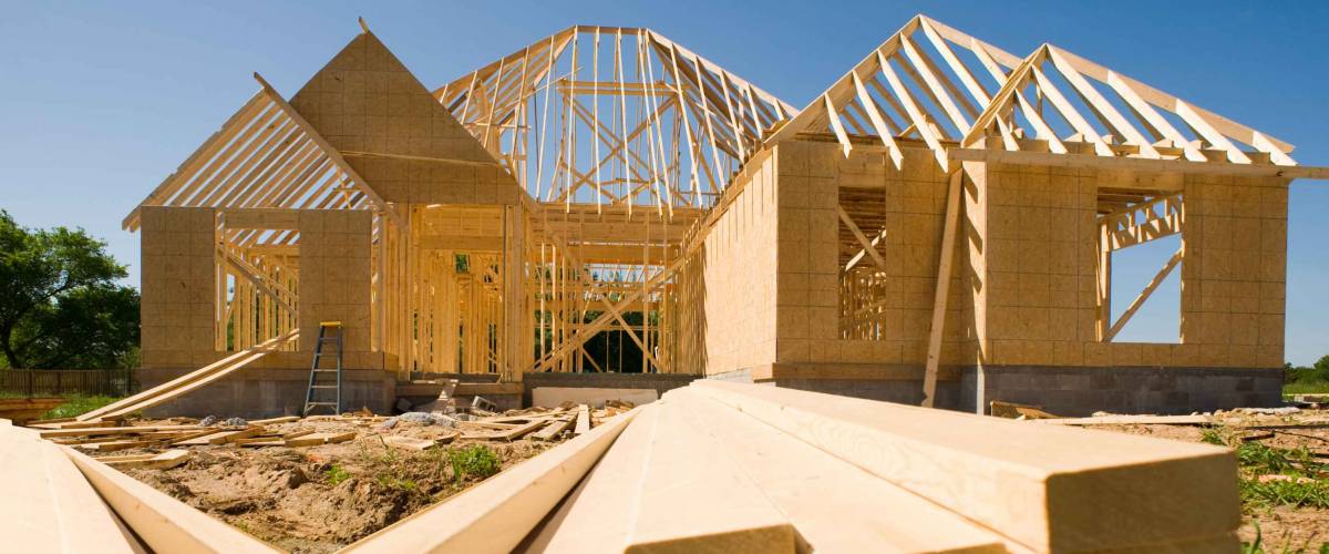 A new home being built with wood, trusses, supports and a foundation.