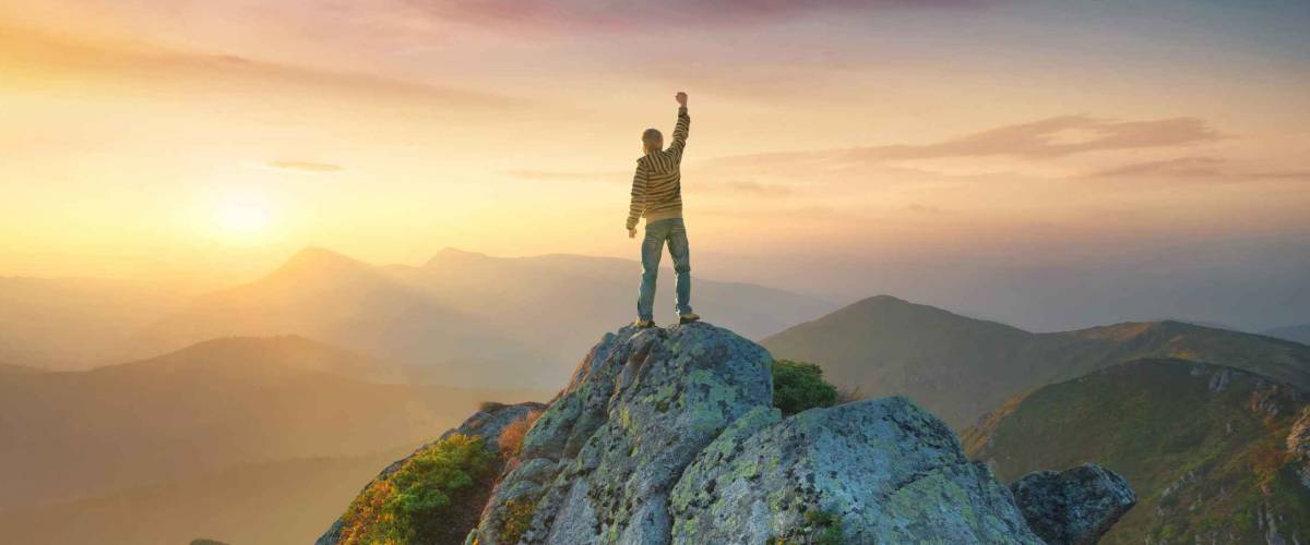 Tourist on the peak of high rocks. Sport and active life concept