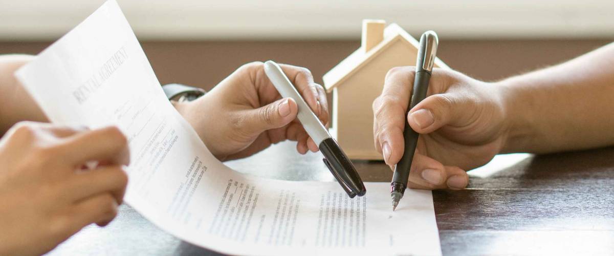 Hand of broker showing to client where to sign signature contract.