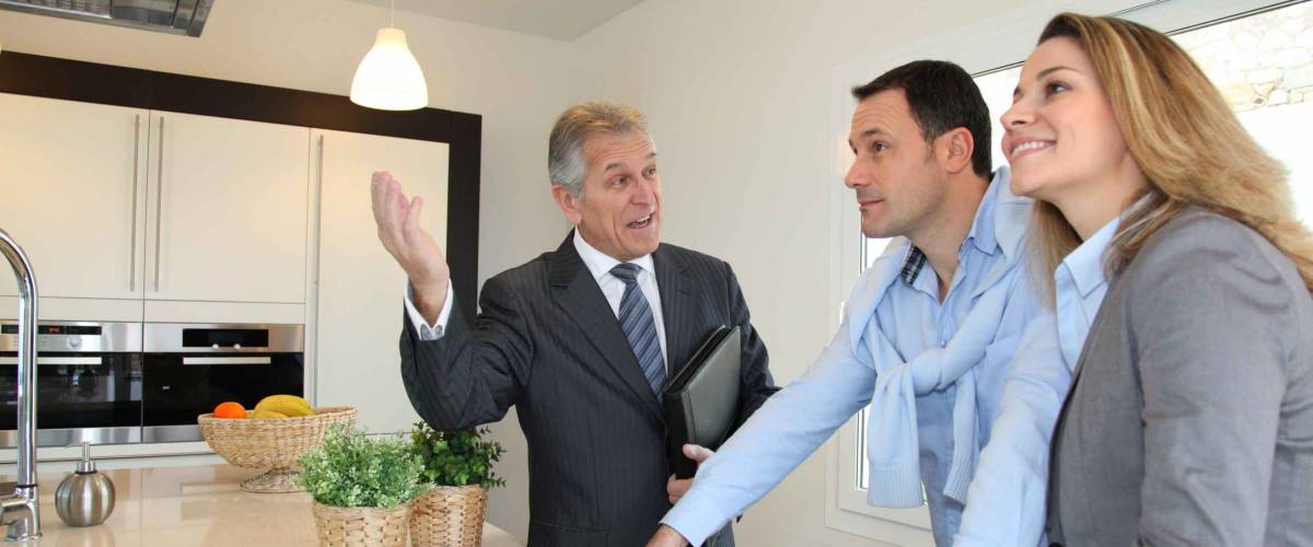 Real estate agent showing modern house to couple