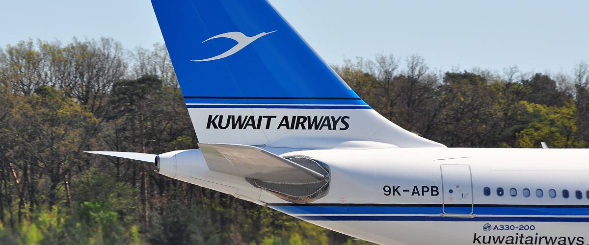 Kuwait Airways airplane tail on the ground.