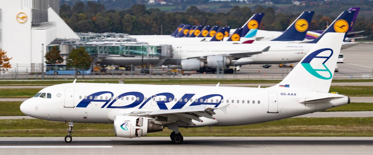 Adria Airways airplane on the ground.