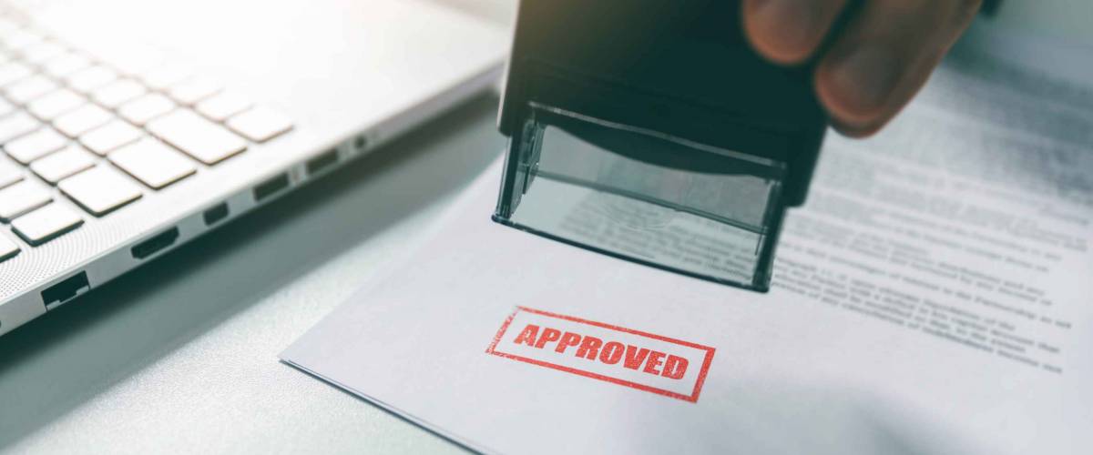 approved stamp - businessman stamping document in office