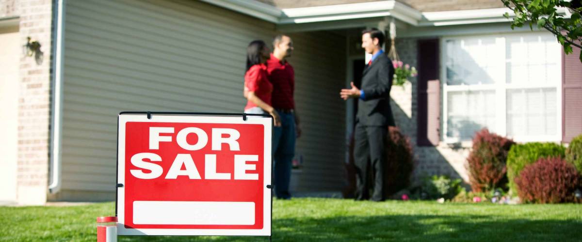 Real Estate: For Sale Sign With Agent And Home Buyer Behind