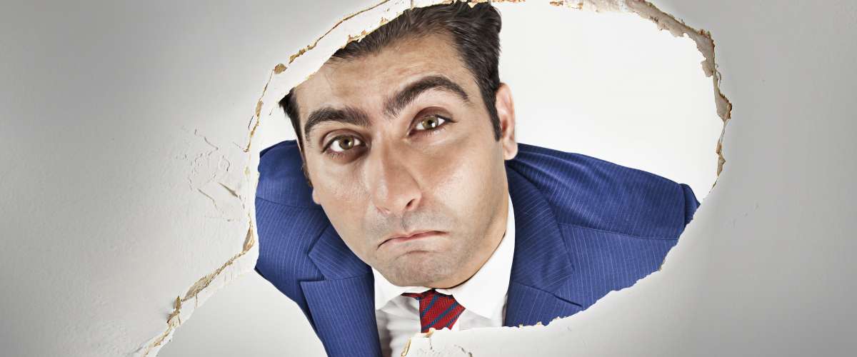man looking through a hole in the roof