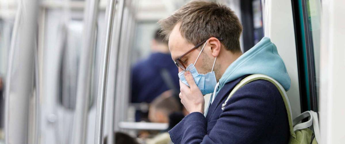 Ill man in glasses wearing a face mask to protect against coronavirus