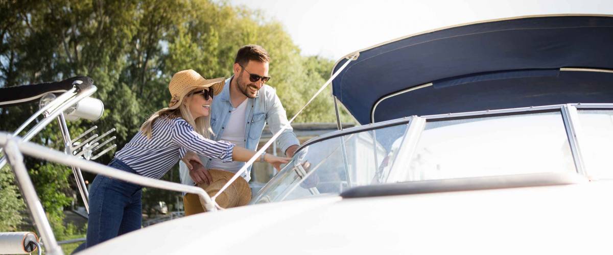 A beautiful young couple watches a motor boat that they intend to buy.