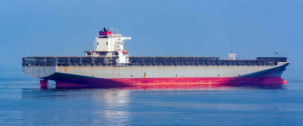 Container freighter ship with empty upper deck anchored near Shanghai port, China