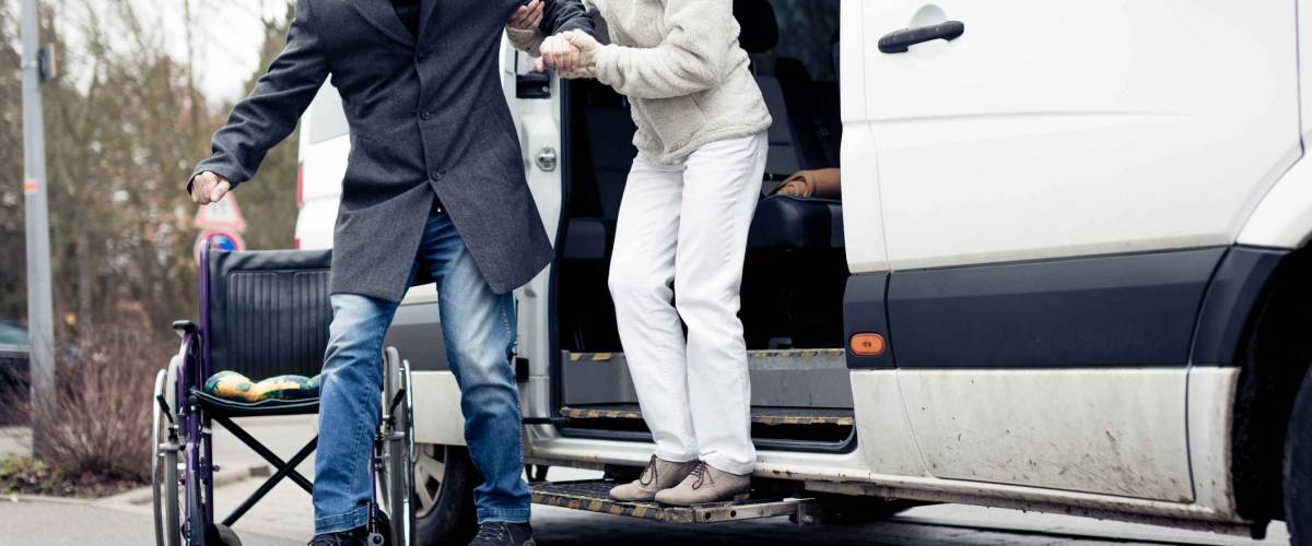Nurse Helping Senior Man Exit A Van