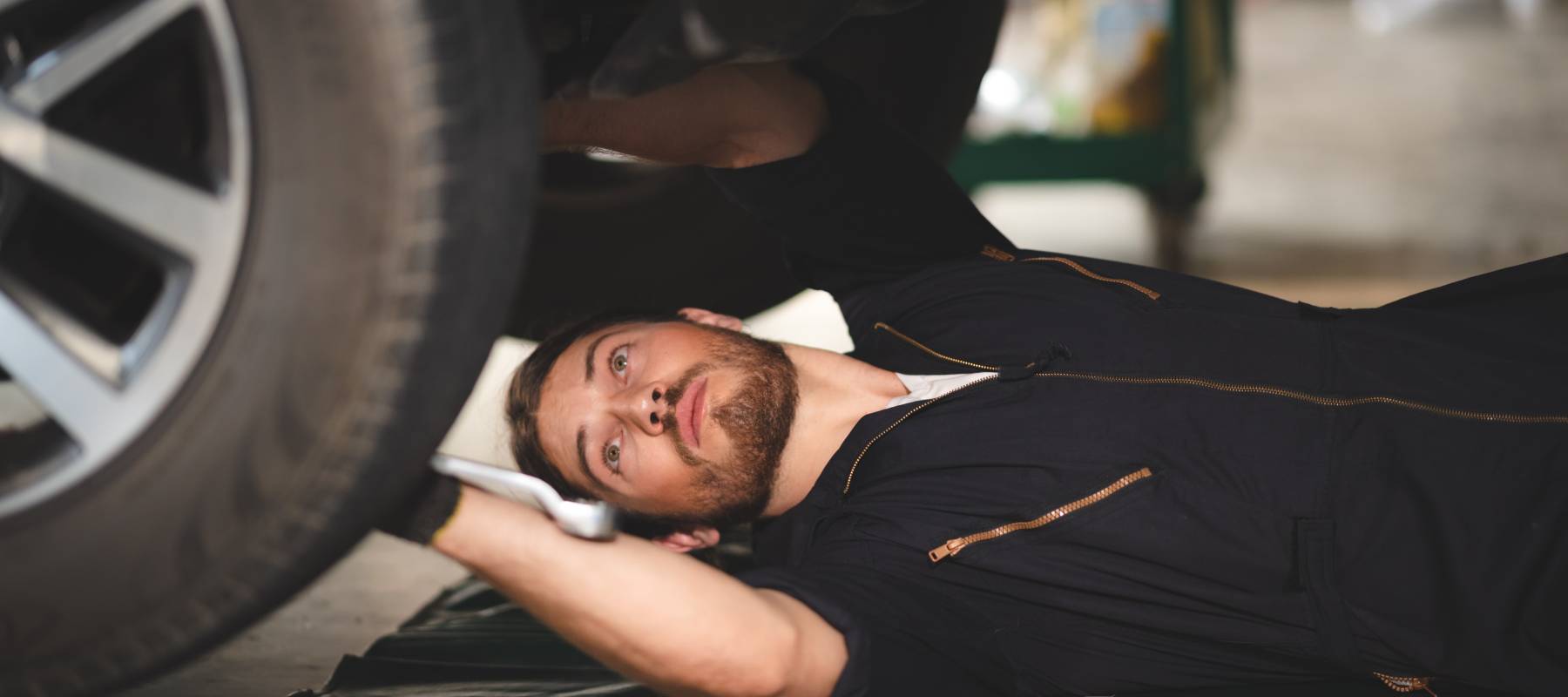 Young man working on car in auto shop