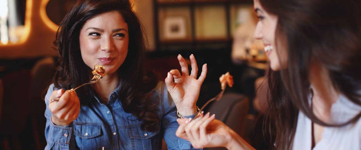 Two young women at a lunch in a restaurant