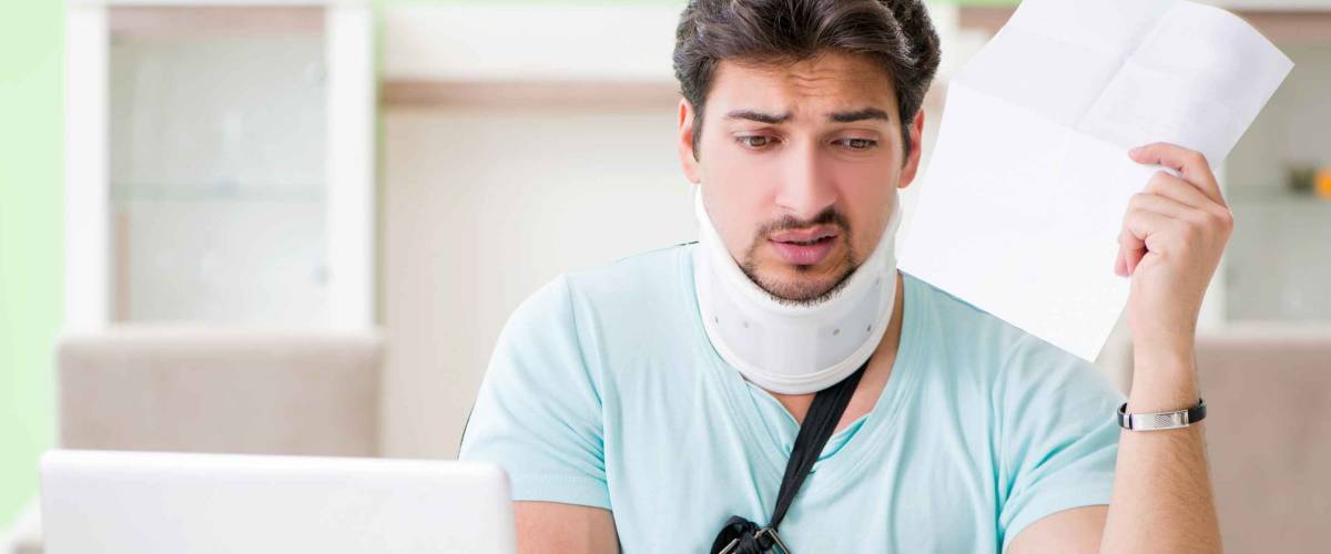 Young student man with neck and hand injury at home