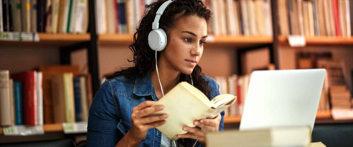 Young female student study in the school library.She using laptop and learning online.