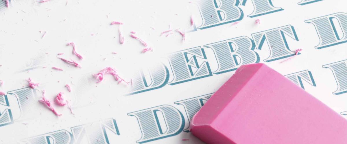 Pink eraser erasing multiple debts written in money font.