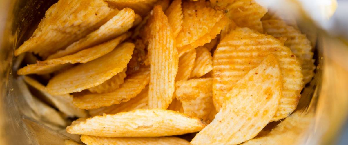 Potato chips is snack in bag ready to eat and fat food or junk food., Potato chips in bag On a wooden table, Crispy potato chips in a wicker bowl on old kitchen table