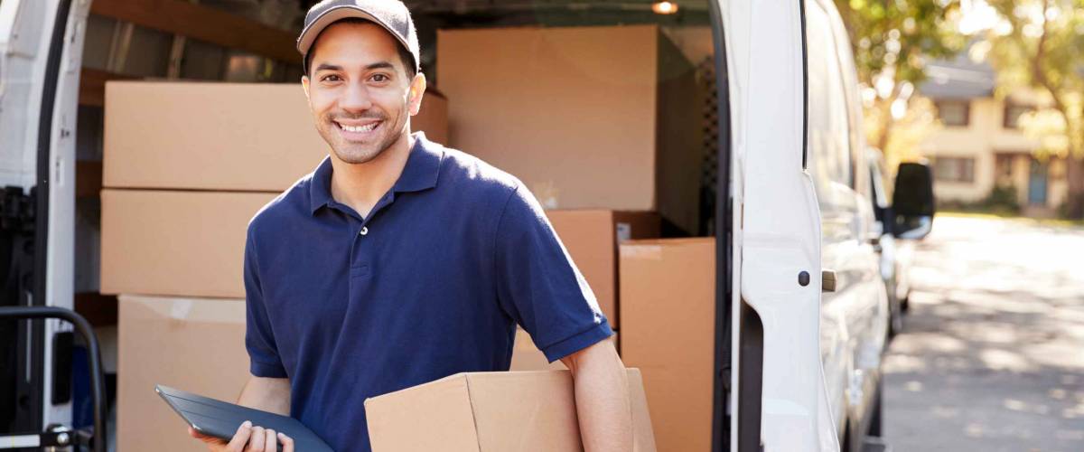 Portrait Of Courier With Digital Tablet Delivering Package