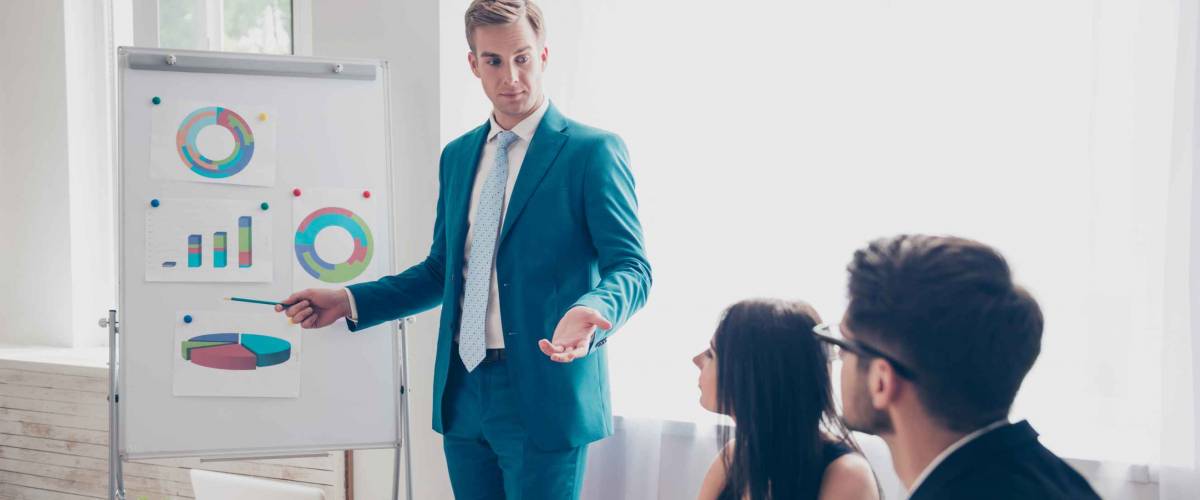 Young manager presenting whiteboard to his colleagues about financial growth