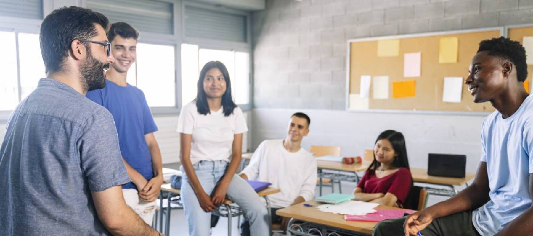 High school teacher conversing with students