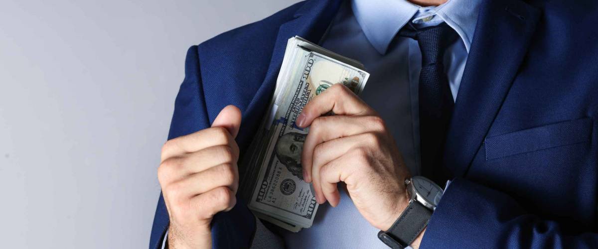 Man putting bribe into pocket on grey background, closeup