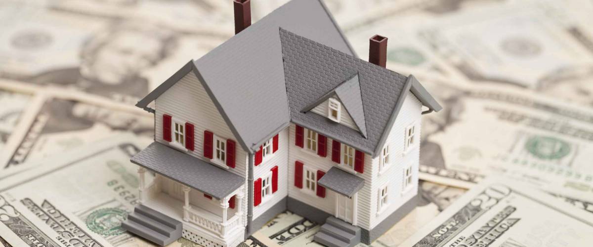 Single family house on pile of money. Concept of real estate.