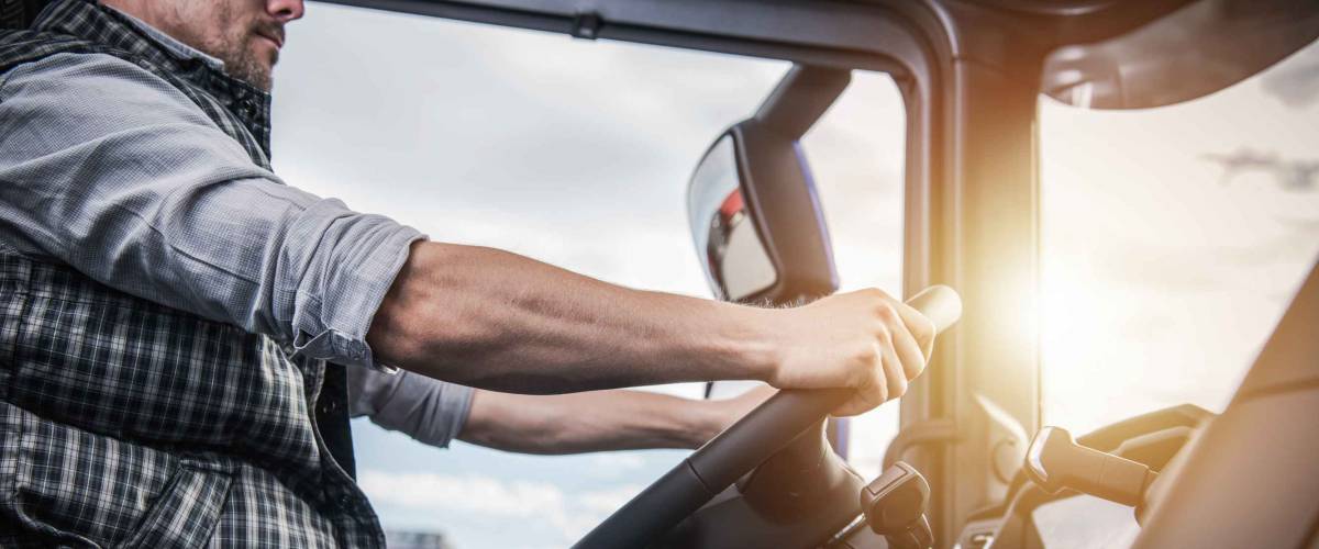 Truck Driver Behind the Wheel. Semi Truck Driving and Transportation Industry.