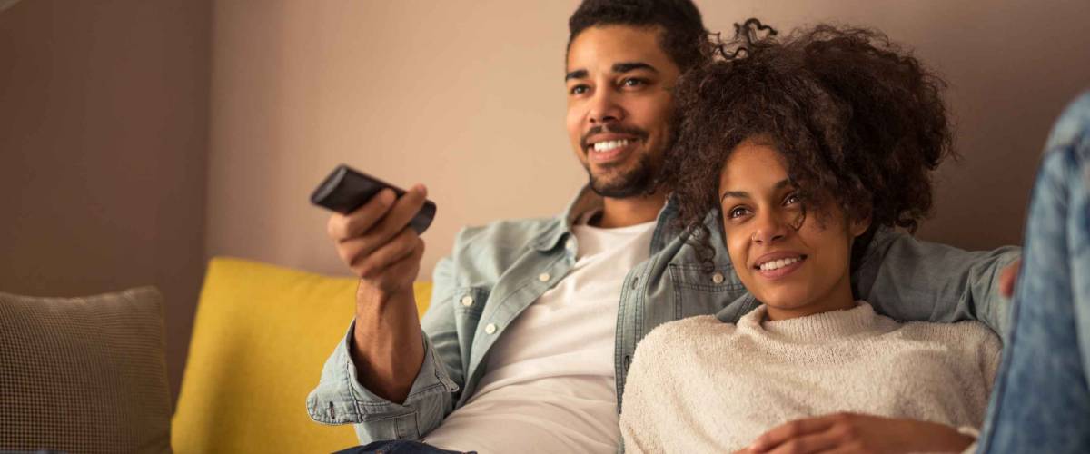 Cropped shot of a young african american couple watching television at home