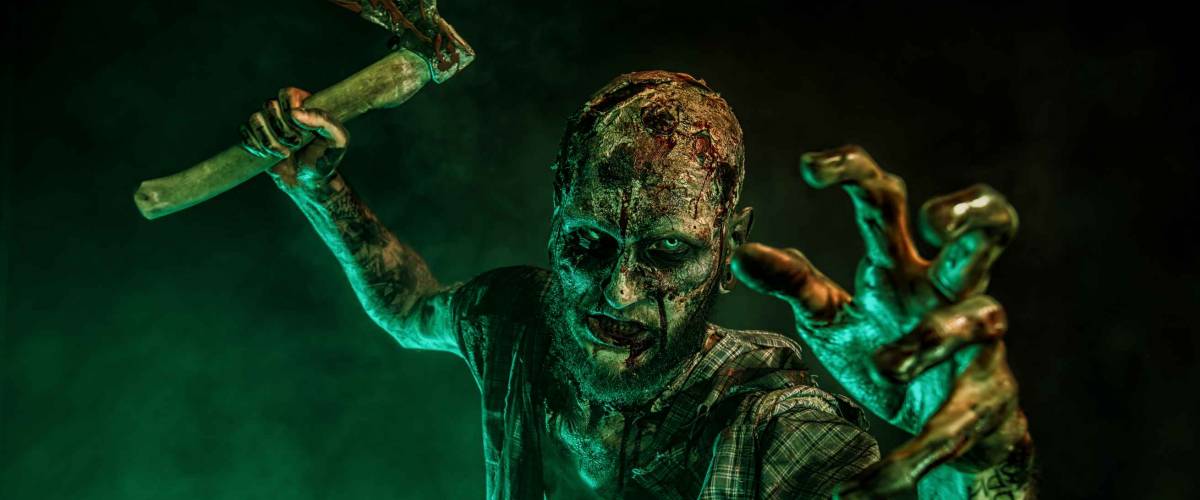 Portrait of a scary zombie with an axe.