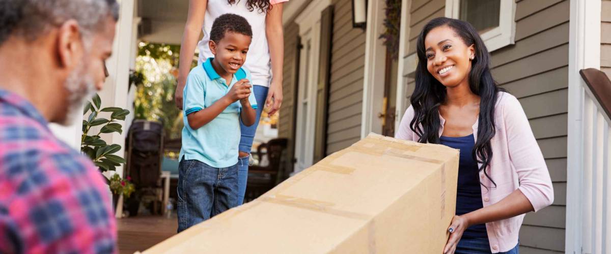 Family Carrying Big Box Purchase Into House