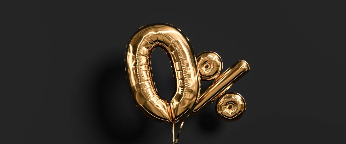 Black hand sculpture holding Zero percent symbol. 0 % offer golden flying foil balloons on yellow. Loan rate fee concept.