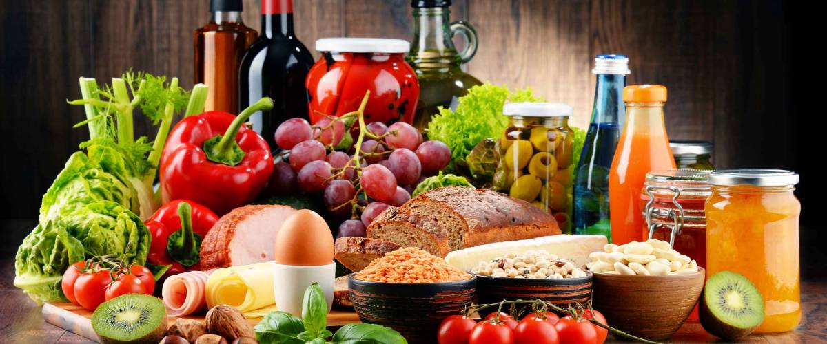 Composition with variety of organic food products on kitchen table