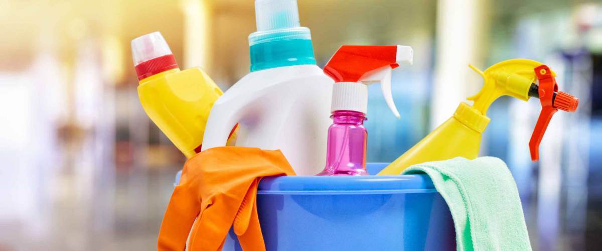 Basket with cleaning items on blurry background