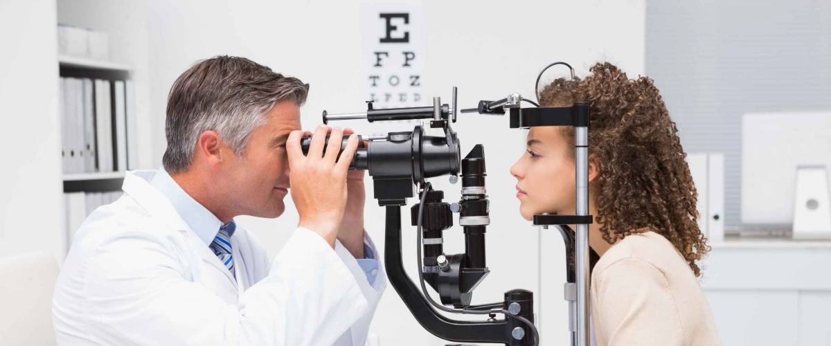 Woman doing eye test with optometrist in medical office