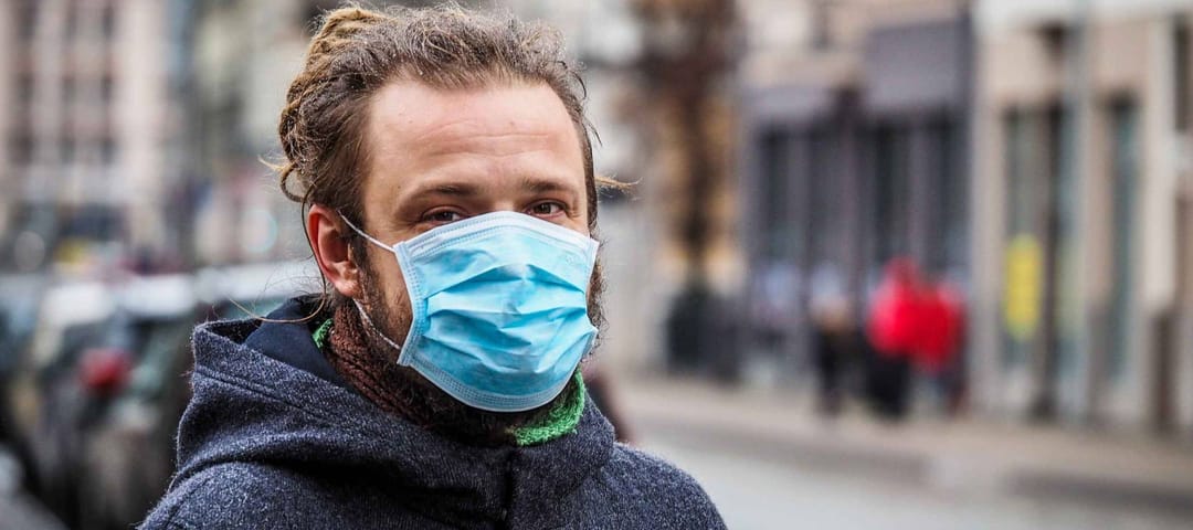 Man on the street wearing face mask to protect against the coronavirus