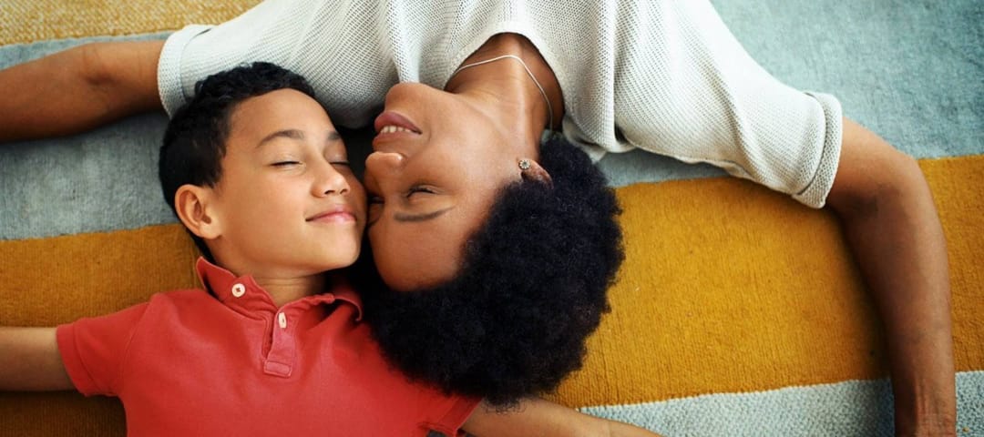 Mother and child snuggling on a striped carpet