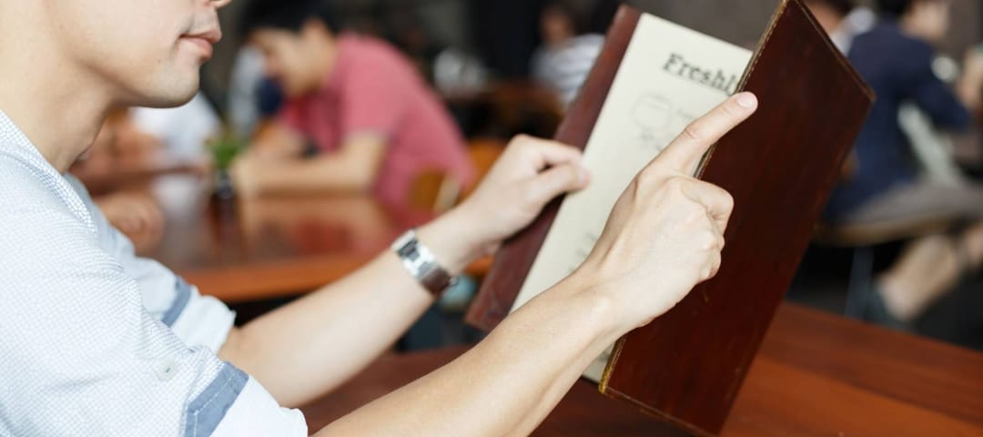 Close up hands holding restaurant menu for dinner dating.