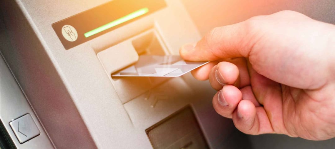Hand of a man with a credit card, using an ATM. Man using an atm machine with his credit card.