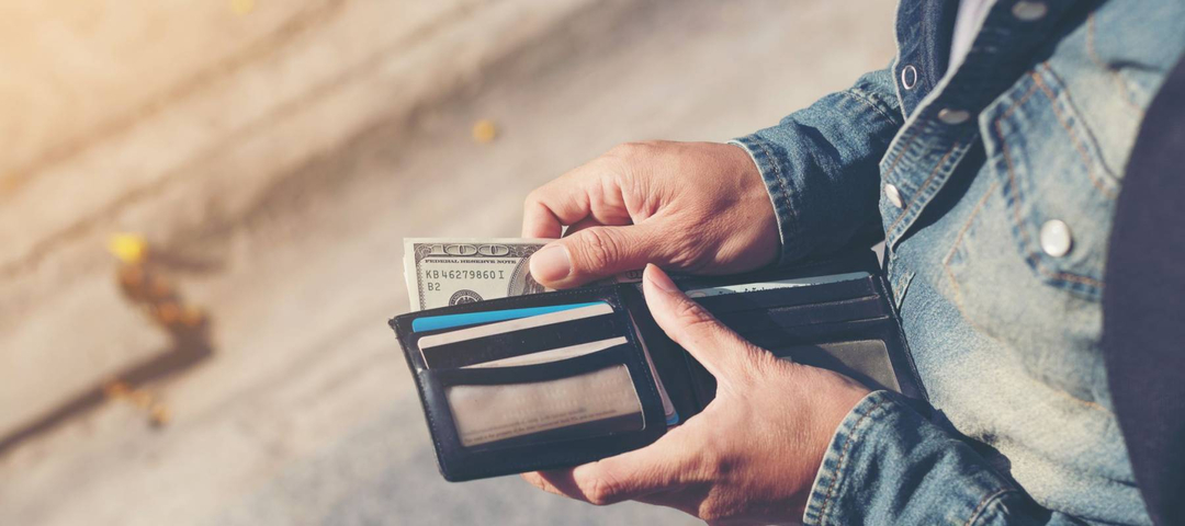 Hipster man hands holding wallet with credit cards and stack of money.
