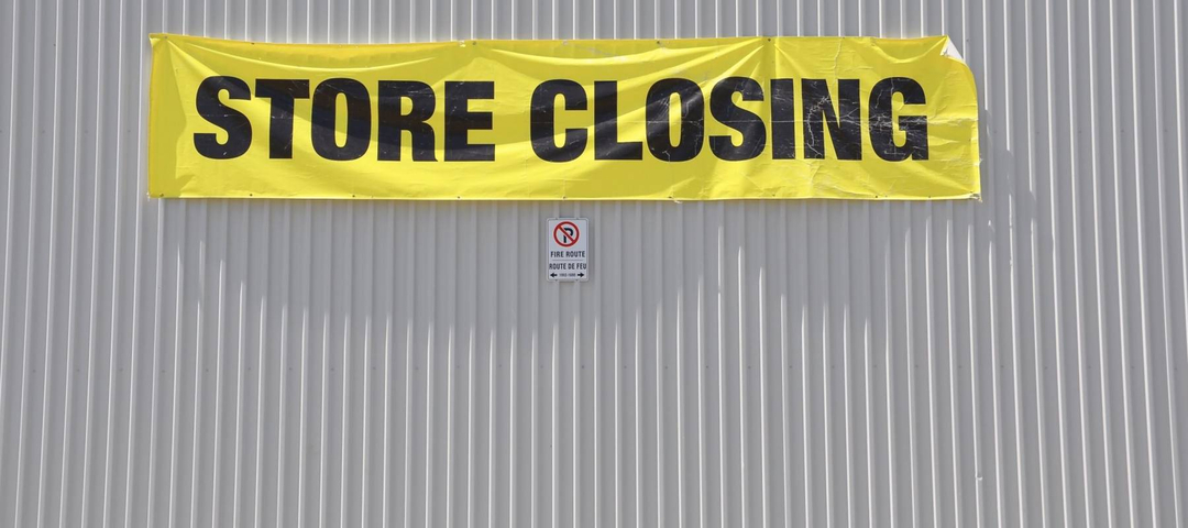 Store closing sign hanging on the concrete wall