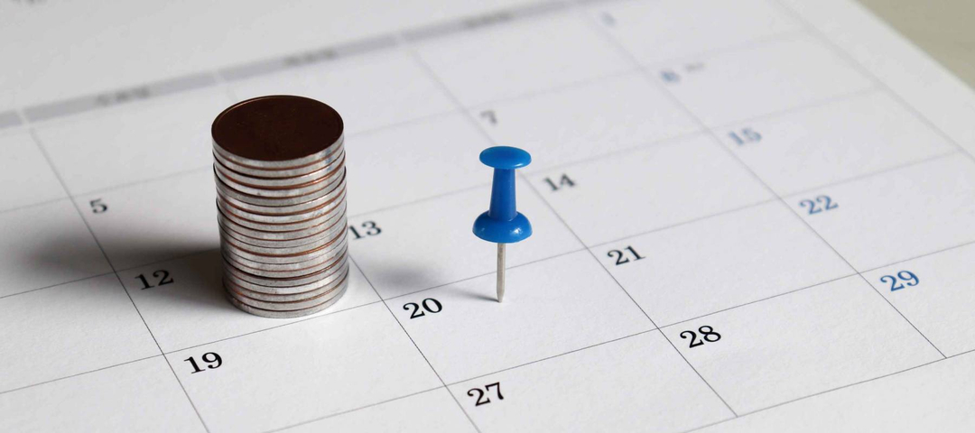 A pile of coins and a blue tack on the calendar.