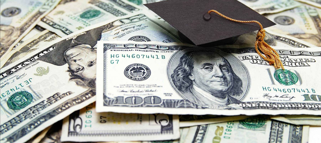 mini graduation cap on US money -- education costs