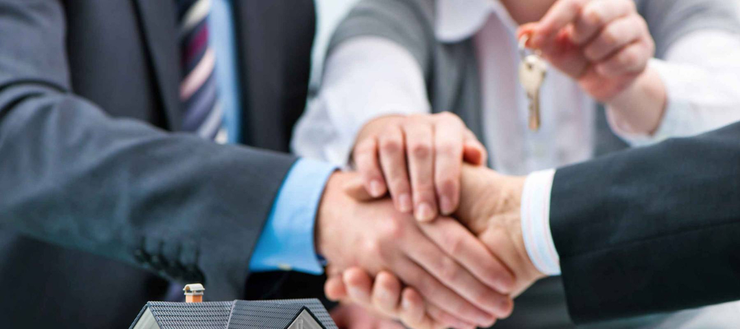 Estate agent shaking hands with customer after contract signature